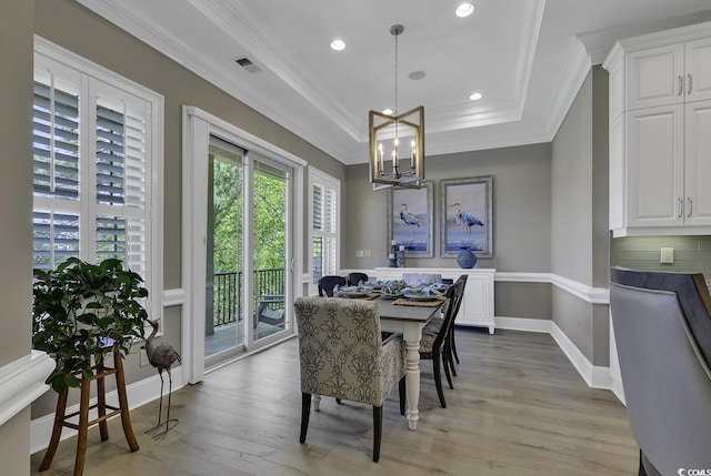 1108 Surf Pointe Dr, North Myrtle Beach, SC 29582 - dining space with a chandelier, ornamental molding, light wood-type flooring, a raised ceiling, and baseboards