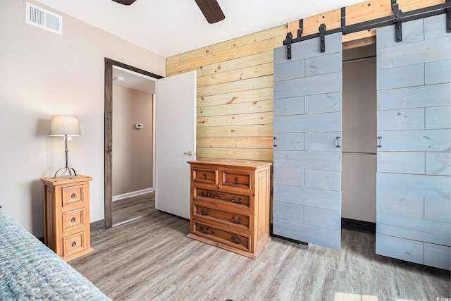 2257 Huntingdon Dr Unit H, Myrtle Beach, SC 29575 - bedroom featuring light wood-type flooring, wood walls, and a barn door