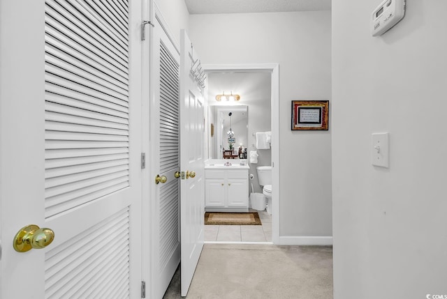 6015 Catalina Dr Unit 733, North Myrtle Beach, SC 29582 - hallway featuring light colored carpet, baseboards, light tile patterned floors, and a sink
