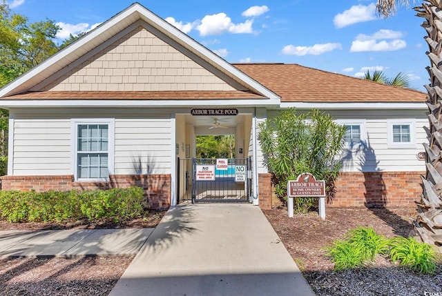 6015 Catalina Dr Unit 733, North Myrtle Beach, SC 29582 - view of exterior entry with a gate, brick siding, and a shingled roof