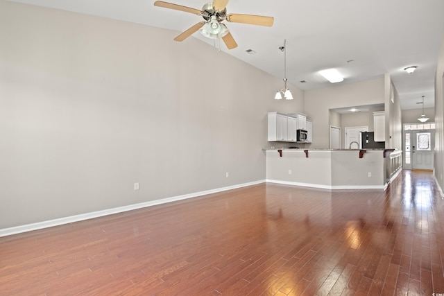 121 Parmelee Dr Unit D, Murrells Inlet, SC 29576 - unfurnished living room with baseboards, ceiling fan, wood finished floors, a sink, and high vaulted ceiling