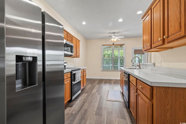 185 Fulbourn Pl, Myrtle Beach, SC 29579 - kitchen with appliances with stainless steel finishes, dark wood-style floors, brown cabinets, a ceiling fan, and recessed lighting