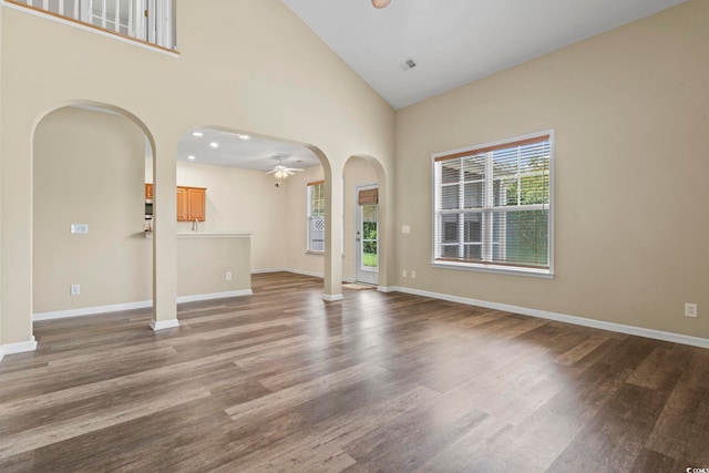 185 Fulbourn Pl, Myrtle Beach, SC 29579 - unfurnished living room featuring arched walkways, a ceiling fan, wood finished floors, high vaulted ceiling, and recessed lighting