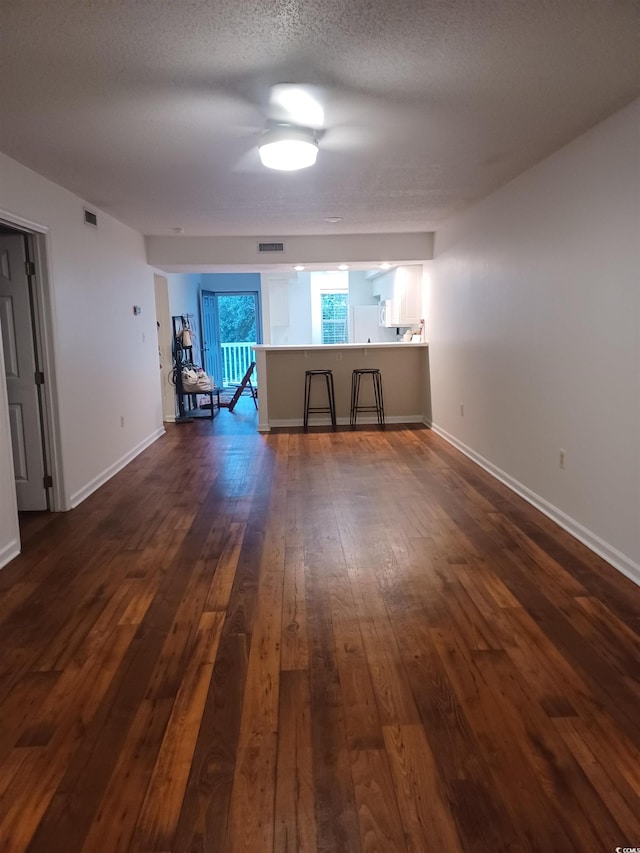 157 Egret Run Ln Unit 523, Pawleys Island, SC 29585 - unfurnished living room featuring dark wood-style flooring and a textured ceiling