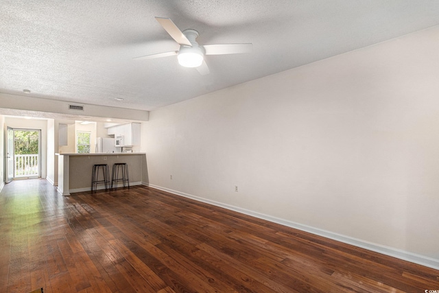 157 Egret Run Ln Unit 523, Pawleys Island, SC 29585 - unfurnished living room with dark wood-type flooring, a ceiling fan, and a textured ceiling