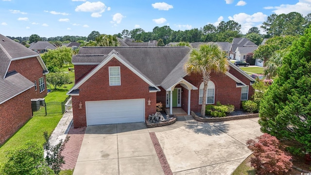 2384 Covington Dr, Myrtle Beach, SC 29579 - traditional-style home with an attached garage, concrete driveway, brick siding, a gate, and a residential view
