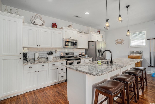 58 Fathom Ln, Murrells Inlet, SC 29576 - kitchen with stainless steel appliances, a sink, decorative backsplash, dark wood-style floors, and a kitchen breakfast bar