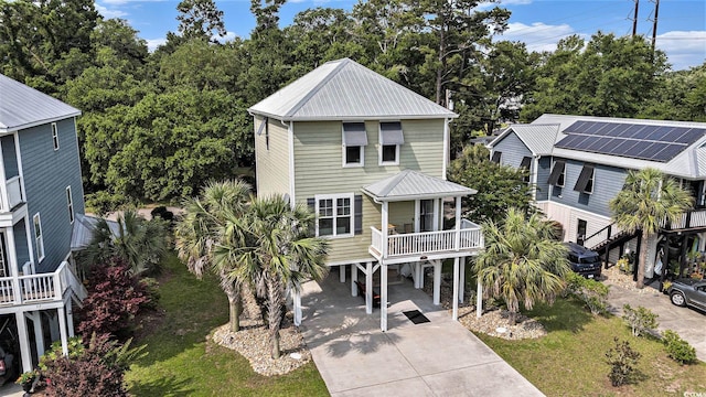 58 Fathom Ln, Murrells Inlet, SC 29576 - coastal inspired home with a carport, concrete driveway, metal roof, view of scattered trees, and a front lawn