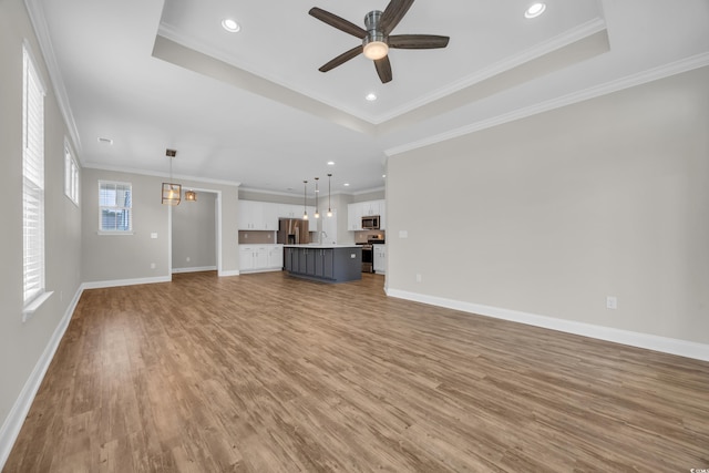 2080 Silver Island Way, Murrells Inlet, SC 29576 - unfurnished living room featuring a raised ceiling, light wood-type flooring, ceiling fan, ornamental molding, and baseboards