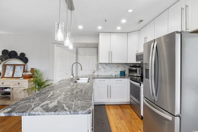 1101 Possum Trot Rd Unit D201, North Myrtle Beach, SC 29582 - kitchen featuring appliances with stainless steel finishes, a peninsula, light wood-style floors, white cabinetry, and backsplash