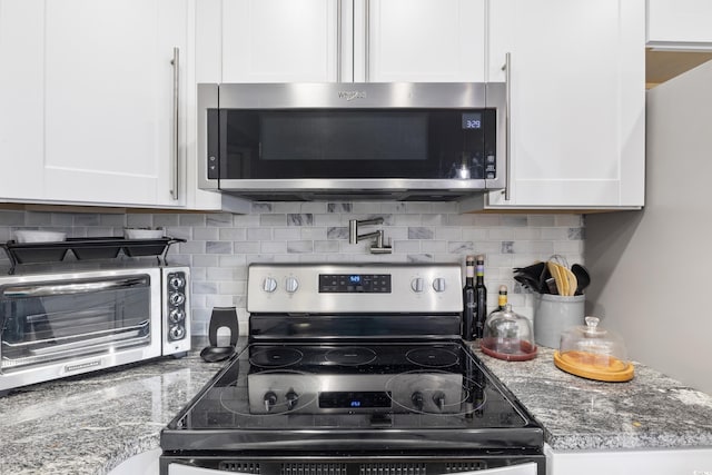 1101 Possum Trot Rd Unit D201, North Myrtle Beach, SC 29582 - kitchen featuring appliances with stainless steel finishes, white cabinetry, and tasteful backsplash