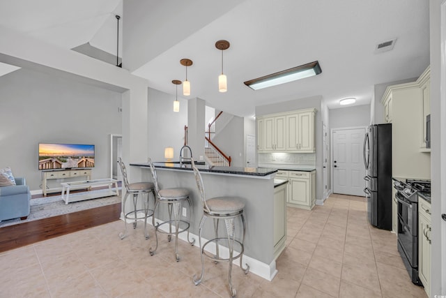 4232 Pointer Ct, Myrtle Beach, SC 29579 - kitchen featuring cream cabinets, appliances with stainless steel finishes, a kitchen bar, and light tile patterned flooring