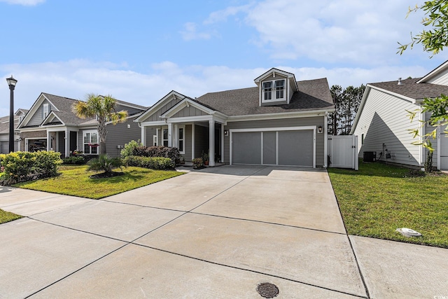 1741 Parish Way, Myrtle Beach, SC 29577 - view of front of house with a front yard, concrete driveway, board and batten siding, cooling unit, and a gate