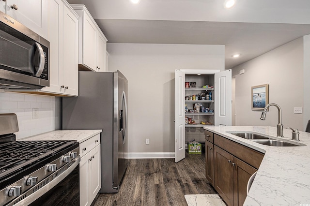 1741 Parish Way, Myrtle Beach, SC 29577 - kitchen featuring appliances with stainless steel finishes, a sink, dark wood finished floors, tasteful backsplash, and white cabinetry