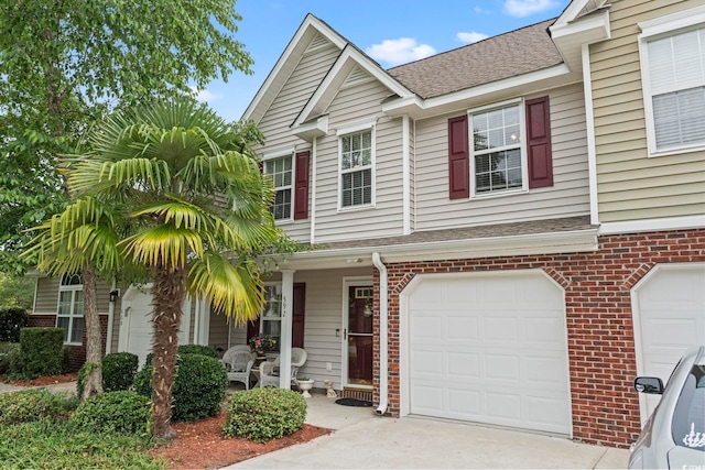 592 Riverward Dr Unit 592, Myrtle Beach, SC 29588 - townhome / multi-family property with brick siding, a shingled roof, a porch, concrete driveway, and a garage