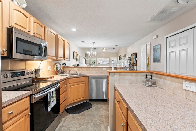 592 Riverward Dr Unit 592, Myrtle Beach, SC 29588 - kitchen with appliances with stainless steel finishes, a sink, light countertops, backsplash, and a textured ceiling
