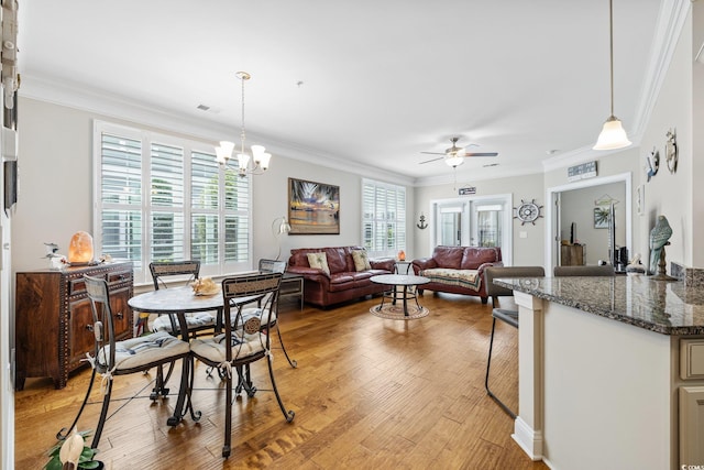 172 Ella Kinley Cir Unit 101, Myrtle Beach, SC 29588 - dining room featuring ceiling fan, ornamental molding, light wood-style flooring, and a chandelier