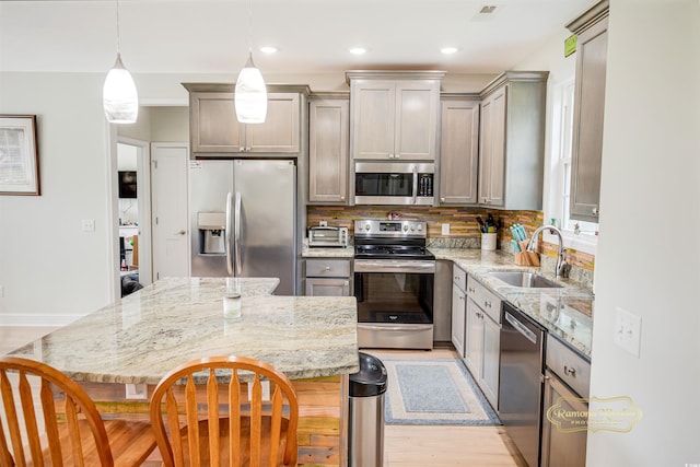 1013 Happy Ln, Galivants Ferry, SC 29544 - kitchen with stainless steel appliances, a sink, a breakfast bar area, light stone counters, and a center island