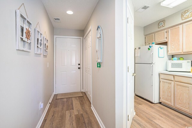 1900 Duffy St Unit L4, North Myrtle Beach, SC 29582 - hall featuring light wood-style flooring, baseboards, and a textured ceiling