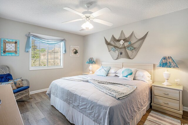 1900 Duffy St Unit L4, North Myrtle Beach, SC 29582 - bedroom featuring wood finished floors, baseboards, a textured ceiling, and ceiling fan