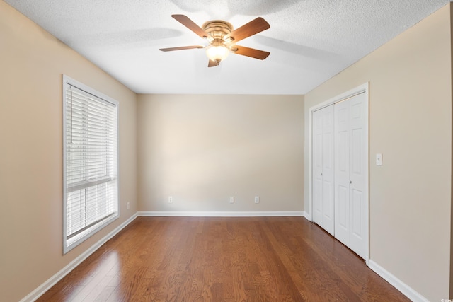 403 75th Ave N Unit C, Myrtle Beach, SC 29572 - unfurnished bedroom featuring dark wood-style floors, a closet, a textured ceiling, baseboards, and a ceiling fan