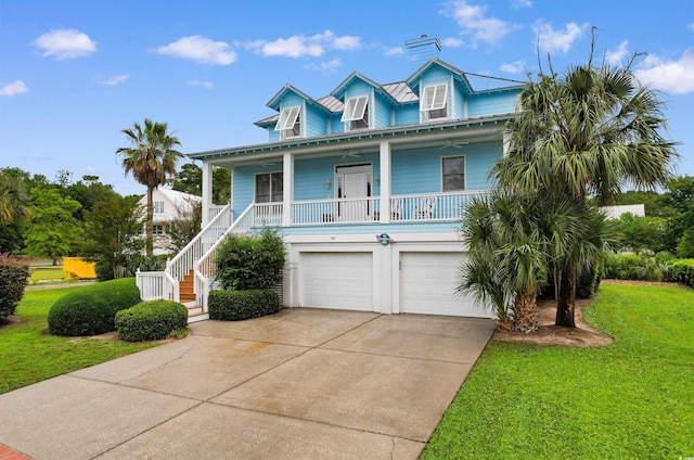 141 Cayman Loop, Pawleys Island, SC 29585 - raised beach house with an attached garage, a front lawn, concrete driveway, a porch, and stairs