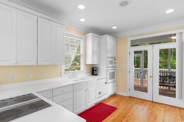 141 Cayman Loop, Pawleys Island, SC 29585 - kitchen with white appliances, french doors, a sink, white cabinetry, and ornamental molding