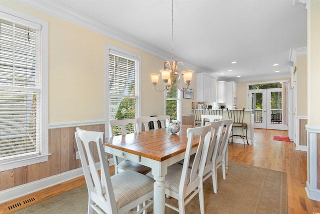141 Cayman Loop, Pawleys Island, SC 29585 - dining room with plenty of natural light, a chandelier, ornamental molding, wainscoting, and french doors