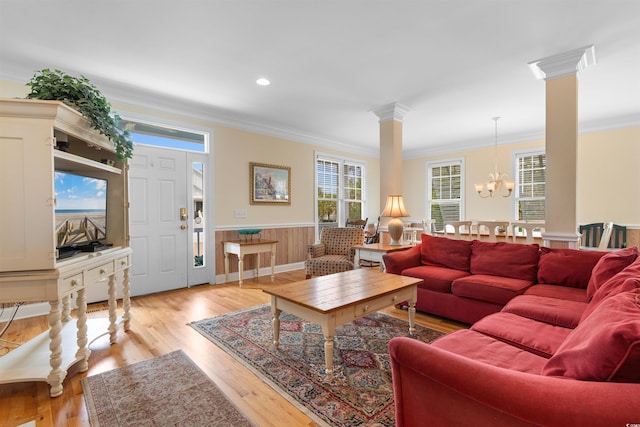 141 Cayman Loop, Pawleys Island, SC 29585 - living room with crown molding, wainscoting, light wood-style floors, a chandelier, and ornate columns