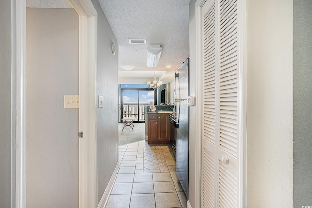 2600 N Ocean Blvd Unit 1406, Myrtle Beach, SC 29577 - hall featuring light tile patterned floors, a textured ceiling, and a chandelier
