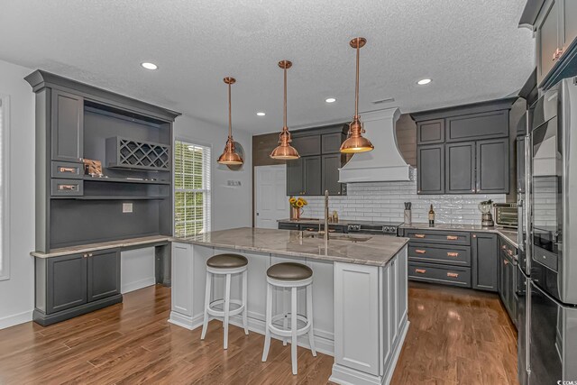 4600 Murrells Inlet Rd, Murrells Inlet, SC 29576 - kitchen featuring premium range hood, open shelves, light stone counters, dark wood-type flooring, and tasteful backsplash