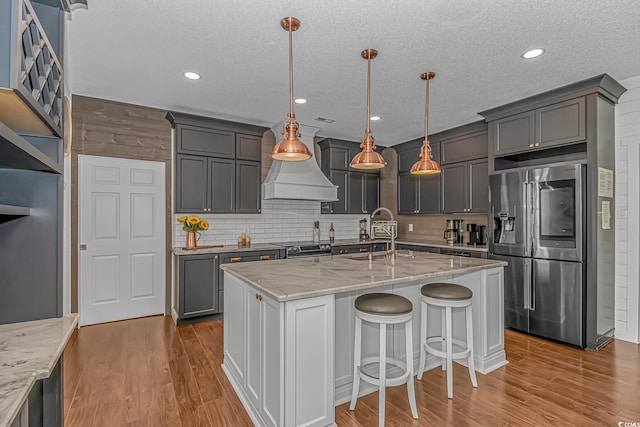 4600 Murrells Inlet Rd, Murrells Inlet, SC 29576 - kitchen with appliances with stainless steel finishes, light stone counters, wood finished floors, backsplash, and a textured ceiling