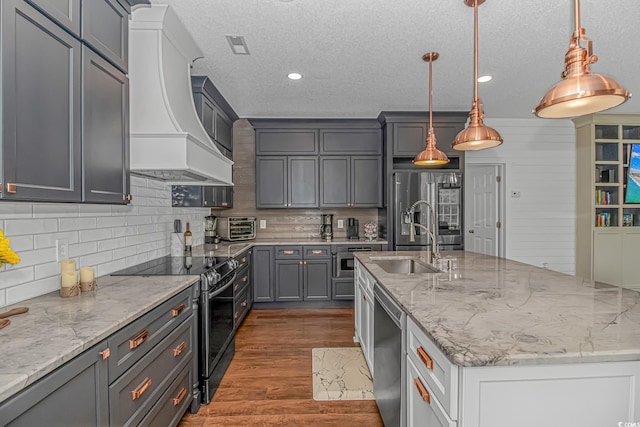 4600 Murrells Inlet Rd, Murrells Inlet, SC 29576 - kitchen with appliances with stainless steel finishes, custom range hood, backsplash, a textured ceiling, and an island with sink