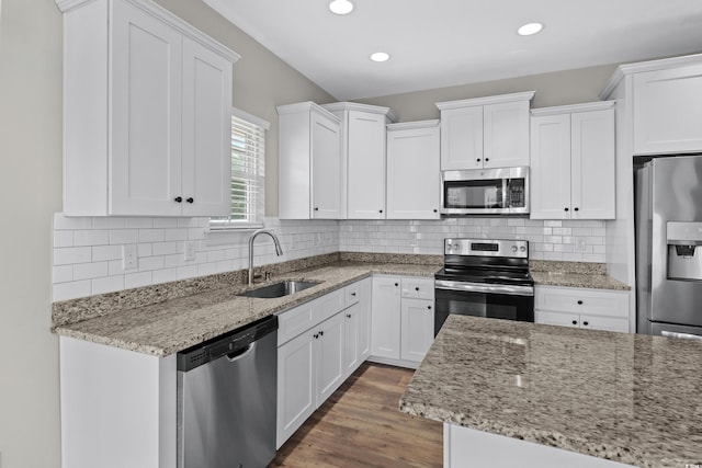 104 Browns Hollow Ct, Loris, SC 29569 - kitchen featuring stainless steel appliances, white cabinets, light stone counters, wood finished floors, and backsplash