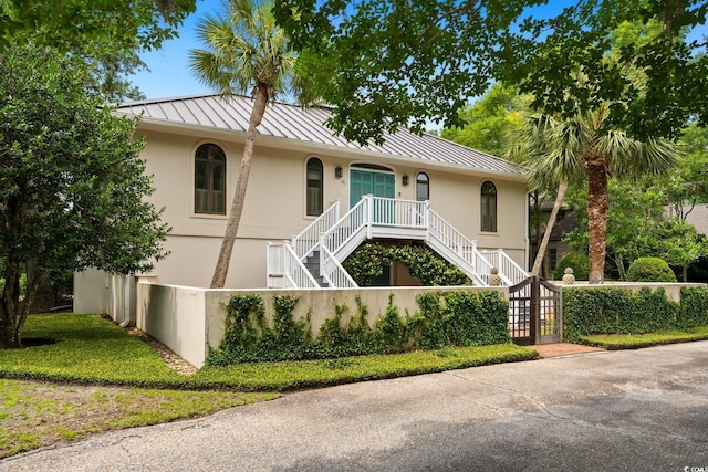 95 Sanderling Ave, Georgetown, SC 29440 - view of front of property with a standing seam roof, stairs, stucco siding, covered porch, and metal roof