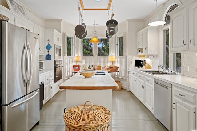 95 Sanderling Ave, Georgetown, SC 29440 - kitchen featuring appliances with stainless steel finishes, a kitchen island, a sink, white cabinetry, and light wood-style flooring