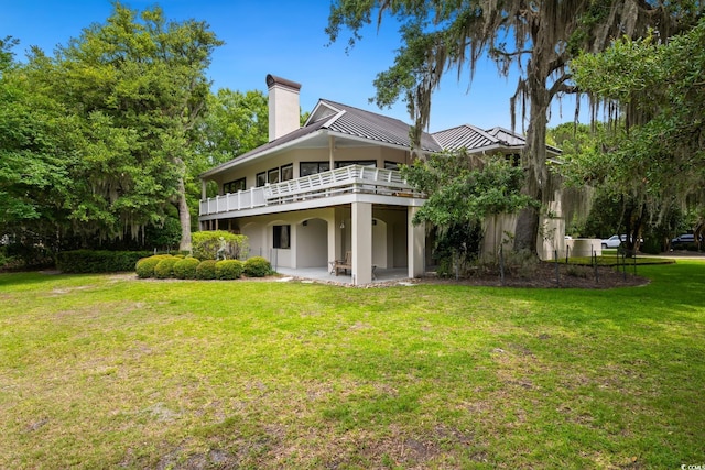 95 Sanderling Ave, Georgetown, SC 29440 - rear view of property featuring a chimney, a standing seam roof, stucco siding, a yard, and a patio area