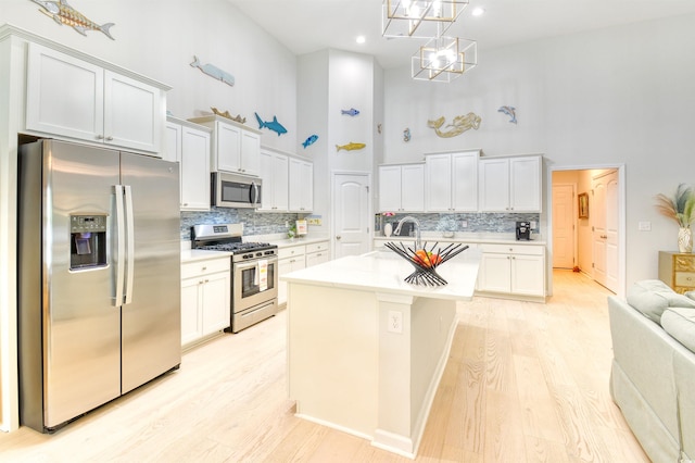 631 Rycola Cir, Surfside Beach, SC 29575 - kitchen with stainless steel appliances, a high ceiling, decorative backsplash, light wood finished floors, and light countertops