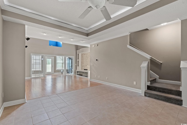 4378 Willoughby Ln Unit 4378, Myrtle Beach, SC 29577 - unfurnished living room with crown molding, light tile patterned flooring, a ceiling fan, stairway, and a tray ceiling