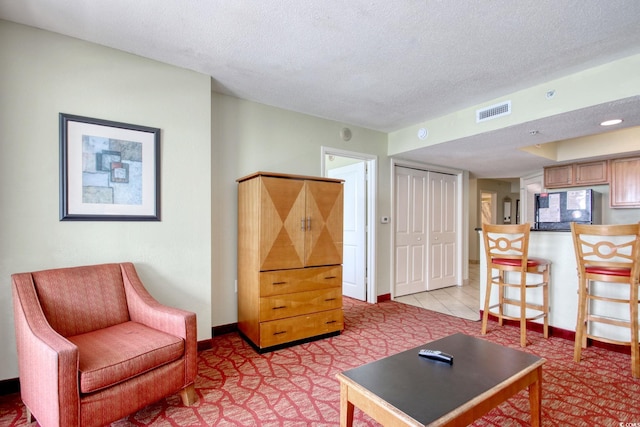 504 N Ocean Blvd Unit 1106, Myrtle Beach, SC 29577 - living room featuring a textured ceiling, baseboards, and light colored carpet