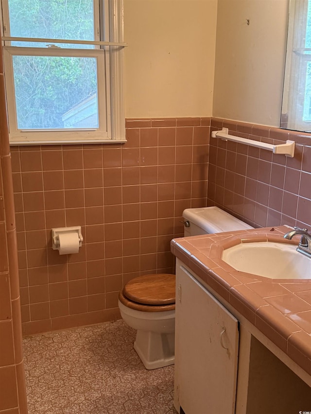 4909 Yaupon Cir, Myrtle Beach, SC 29575 - half bathroom with toilet, vanity, healthy amount of natural light, a wainscoted wall, and tile walls