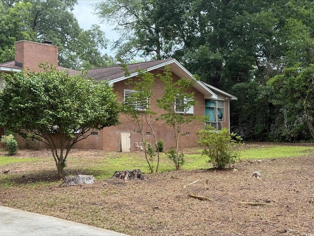 4909 Yaupon Cir, Myrtle Beach, SC 29575 - view of home's exterior featuring brick siding and a chimney