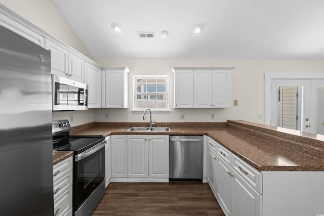 9580 Kings Rd, Myrtle Beach, SC 29572 - kitchen featuring appliances with stainless steel finishes, a peninsula, dark countertops, lofted ceiling, and white cabinetry