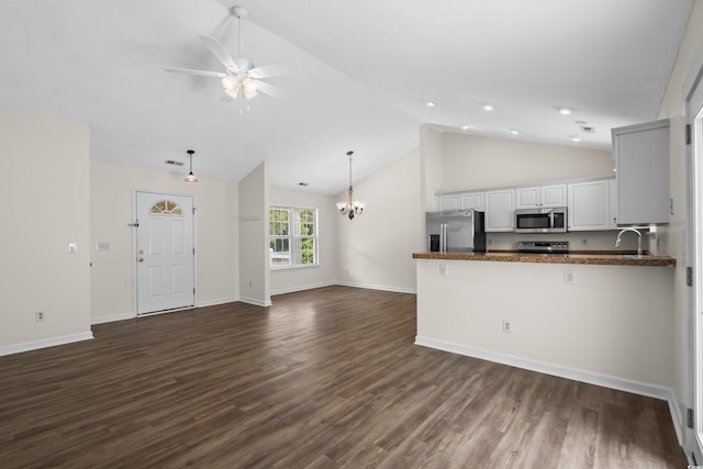9580 Kings Rd, Myrtle Beach, SC 29572 - kitchen with appliances with stainless steel finishes, dark countertops, a peninsula, a chandelier, and white cabinetry