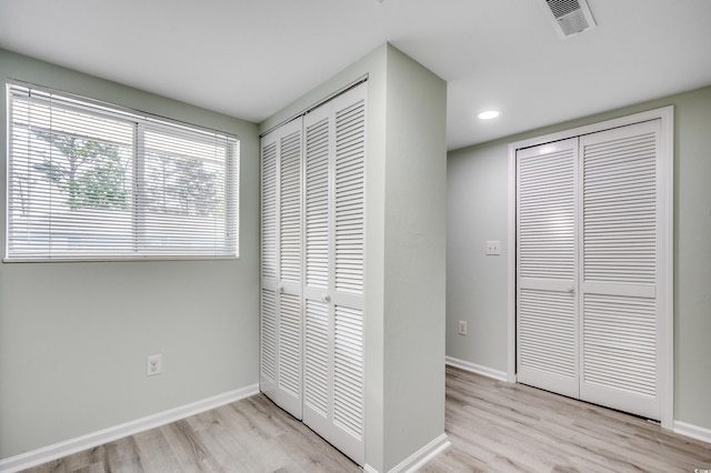 1200 5th Ave N Unit 1207, Surfside Beach, SC 29575 - unfurnished bedroom with light wood-style flooring, baseboards, recessed lighting, and two closets