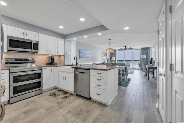 1625 S Ocean Blvd Unit 211, North Myrtle Beach, SC 29582 - kitchen featuring appliances with stainless steel finishes, a peninsula, wooden ceiling, white cabinets, and light wood-style floors