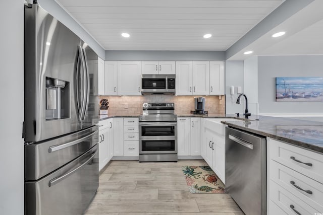 1625 S Ocean Blvd Unit 211, North Myrtle Beach, SC 29582 - kitchen featuring stainless steel appliances, dark stone countertops, white cabinets, light wood-style flooring, and recessed lighting