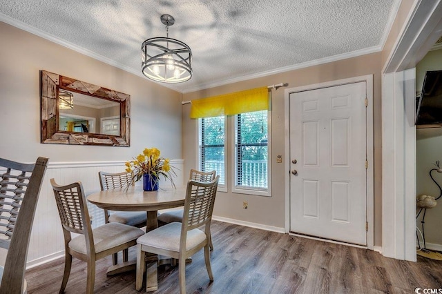 211 N Hillside Dr Unit 204, North Myrtle Beach, SC 29582 - dining space with a textured ceiling, crown molding, wood finished floors, wainscoting, and a chandelier