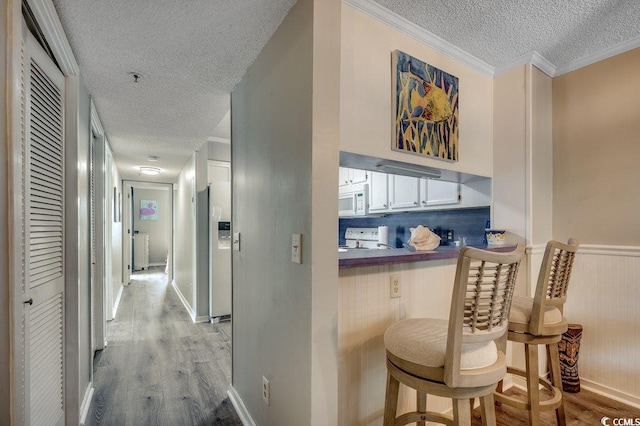 211 N Hillside Dr Unit 204, North Myrtle Beach, SC 29582 - corridor with a textured ceiling, light wood-style floors, crown molding, and a wainscoted wall