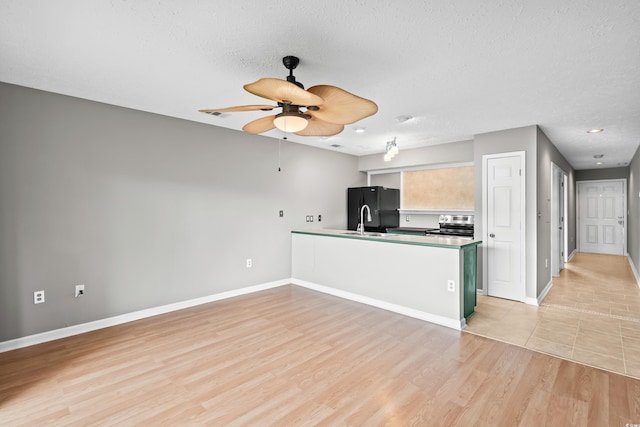 4101 Pinehurst Cir Unit Aa-3, Little River, SC 29566 - kitchen with freestanding refrigerator, electric stove, a peninsula, baseboards, and a textured ceiling